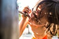 The boy drinks water from the tap