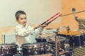 Boy drumming. boy in a white shirt plays the drums. A boy in a white shirt is drumming. toned