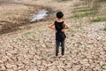 Boy in dryland looking at drought landscape. Concept for climate change from global worming.