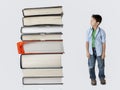 Boy dwarfed by stack of books. Royalty Free Stock Photo