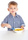 A boy is eating cereal from a bowl Royalty Free Stock Photo