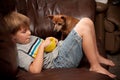 Boy eating cereal with little dog watching Royalty Free Stock Photo