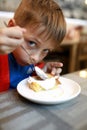 Boy eating cheesecake with sour cream