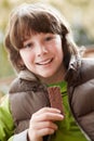 Boy Eating Chocolate Bar Wearing Winter Clothes Royalty Free Stock Photo