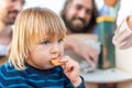 boy eating a cookie with his family in blurry background Royalty Free Stock Photo