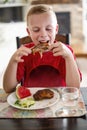 Boy eating a delicious plate of Barbecue ribs, watermelon and salad