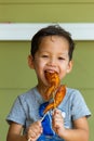 Boy eating grilled chicken