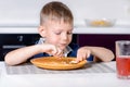 Boy Eating Last Bite of Food at Kitchen Table Royalty Free Stock Photo