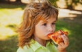 Boy eating pizza. Child pleasure and takes a bite of pizza.