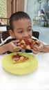 Boy eating pizza with deliciousness