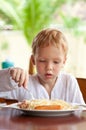 Boy eating spaghetti with sausages outdoors