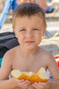 The boy eats a donut on the beach Royalty Free Stock Photo