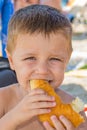 The boy eats a donut on the beach Royalty Free Stock Photo