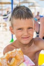 The boy eats a donut on the beach Royalty Free Stock Photo