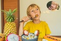 Boy eats fruit but dreams about donuts. Harmful and healthy food for children. Child eating healthy snack. Vegetarian Royalty Free Stock Photo