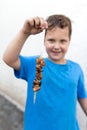 Boy eats kebab on a stick Royalty Free Stock Photo