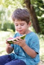 Boy eats watermelon outdoors