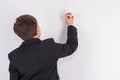 A boy is writing something on a white board. Copy space on white Royalty Free Stock Photo