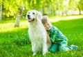 Boy embraces a golden retriever dog on the green grass Royalty Free Stock Photo