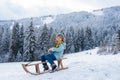 Boy enjoy a sleigh ride. Child sledding, riding a sledge. Children play in snow in winter. Outdoor kids fun for Royalty Free Stock Photo