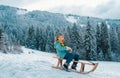 Boy enjoy a sleigh ride. Child sledding, riding a sledge. Children play in snow in winter. Outdoor kids fun for Royalty Free Stock Photo