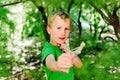 Boy enjoying his summer vacation throwing rocks with a slingshot in a forest Royalty Free Stock Photo
