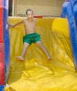 Boy enjoying a wet inflatable slide Royalty Free Stock Photo