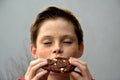 Boy enjoys chocolate pastry with closed eyes Royalty Free Stock Photo