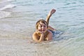 Boy enjoys lying at the beach in the surf