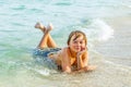 Boy enjoys lying at the beach in the surf Royalty Free Stock Photo