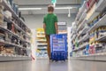 a boy of European appearance with blond short hair in a green T-shirt in a store with his back turned with a blue