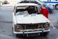 Boy examines rusty with broken windshield car Royalty Free Stock Photo