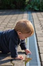 Boy examining gutter in yard