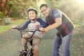 Boy exercises to ride a bike with his dad Royalty Free Stock Photo