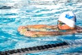 Boy exercising flutter kick with board.