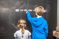 Boy explaining and girl something on the chalkboard