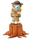 Boy explorer with magnifying glass on tree stump