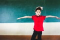 Boy extend the arms with book on head, standing before chalkboard, punishing Royalty Free Stock Photo