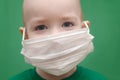 Boy in face mask in a green t-shirt on a green background. child wear facemask during coronavirus and flu outbreak. Virus and