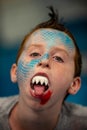 Boy with face painted like a shark