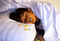 A boy fall asleep while secretly eating candy in bed. Sleep without  brush the teeth routine. Unhealthy lifestyle poor oral hygien Royalty Free Stock Photo