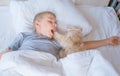 the boy falls asleep and hugs his ginger cat, who sleeps with him under the covers. children and pets. the cat sleeps Royalty Free Stock Photo