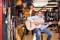 Boy and father choosing acoustic guitar