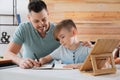 Boy with father doing homework at table