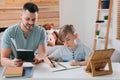 Boy with father doing homework at table