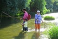 Boy with father and grandfather fly fishing outdoor over river background. Coming together. Father, son and grandfather Royalty Free Stock Photo