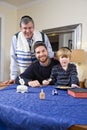 Boy with father and grandfather spinning dreidel Royalty Free Stock Photo