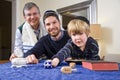 Boy with father and grandfather spinning dreidel Royalty Free Stock Photo