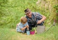 Boy and father in nature with watering can. Gardening tools. Planting flowers. Dad teaching little son care plants Royalty Free Stock Photo