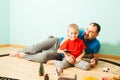 Boy and father playing with his train in the room Royalty Free Stock Photo